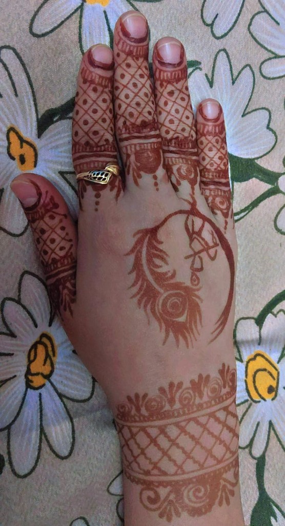 Intricate mehndi with a peacock design on Pankhuri's hand